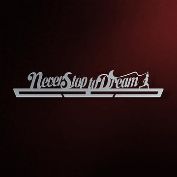Never Stop To Dream Medal Hanger in laser-cut steel on a dark background